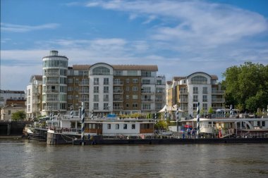 LONDON, UK - 4 Temmuz 2018: Thames nehri üzerindeki Wandsworth 'da tekne ve nehir kenarındaki binalar