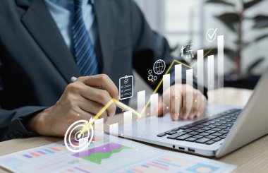 İş adamı maliyet azaltma grafiği ve iş finans stratejisi bütçe yönetimi ve verimlilik ve karlılığın artırılması için kurumsal maliyet kontrolü temsil eden aşağı ok ile sanal ekran kullanıyor.