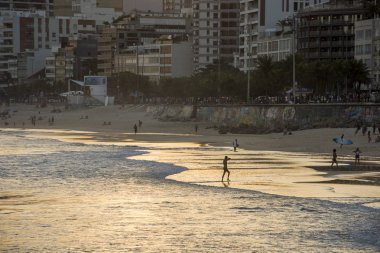 Ipanema Plajı, Rio de Janeiro, Brezilya görülen Atlantik Okyanusu banyo insanların güzel günbatımı manzara