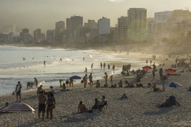 Ipanema Plajı, Rio de Janeiro, Brezilya görülen Atlantik Okyanusu banyo insanların güzel günbatımı manzara