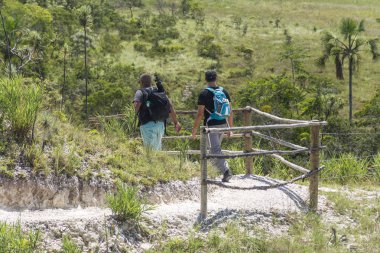 İki genç yetişkinler Chapada dos Veadeiros, Goias, merkezi Brezilya cerrado bitki örtüsü ile iz üzerinde hiking