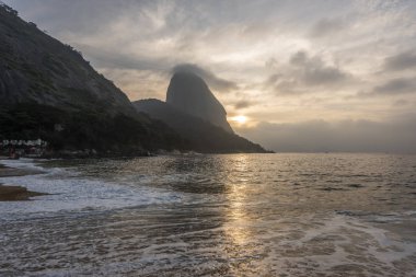 Güzel manzara alacakaranlık ışığı Praia Vermelha, Sugar Loaf Dağı, Atlantik Okyanusu ve güzel bulutlar, gündoğumu sırasında Urca, Rio de Janeiro, Brezilya