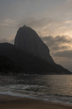 Güzel manzara alacakaranlık ışığı Praia Vermelha, Sugar Loaf Dağı, Atlantik Okyanusu ve güzel bulutlar, gündoğumu sırasında Urca, Rio de Janeiro, Brezilya