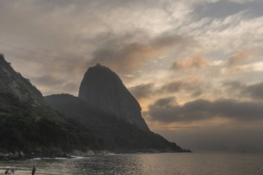 Güzel manzara alacakaranlık ışığı Praia Vermelha, Sugar Loaf Dağı, Atlantik Okyanusu ve güzel bulutlar, gündoğumu sırasında Urca, Rio de Janeiro, Brezilya