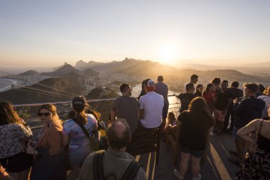 Turistler şehrin güzel manzara ile Sugar Loaf Dağı ve dağlar, Rio de Janeiro, Brezilya gün batımını izlemek