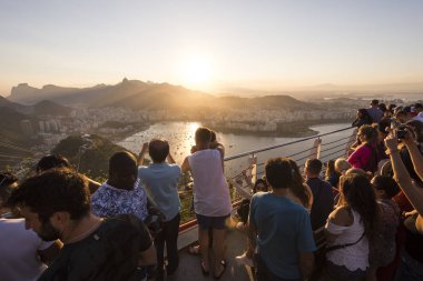 Turistler şehrin güzel manzara ile Sugar Loaf Dağı ve dağlar, Rio de Janeiro, Brezilya gün batımını izlemek