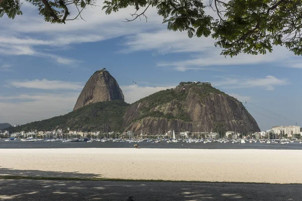 Landscape with view to the Sugar Loaf Mountain from Botafogo Beach on a sunny day with beautiful clouds and blue sky, Rio de Janeiro, Brazil