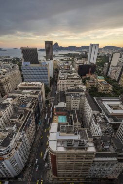 Bina downtown turuncu bulutlar, Rio de Janeiro, Brezilya ile günbatımı zamanı sırasında arka Sugar Loaf Dağı ile güzel manzara