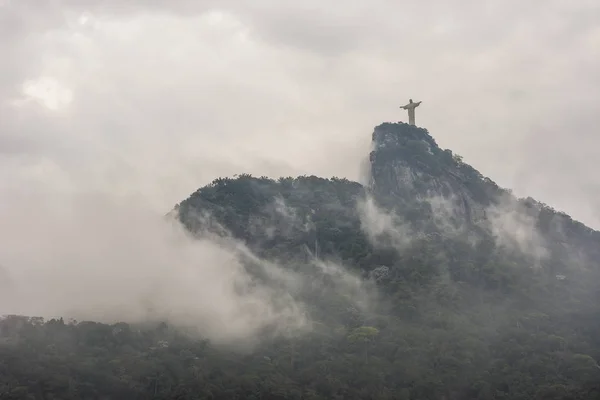 Christ the Redeemer Statue in Tijuca Forest with heavy clouds on top of rainforest Corcovado Mountain, Rio de Janeiro, Brazil