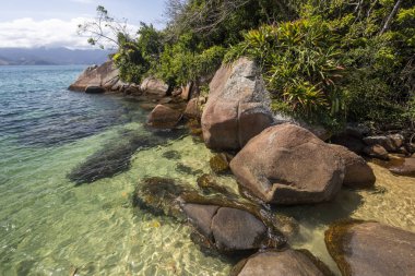 Yeşil su, yemyeşil orman, kayalar ve Ilha Grande, Costa Verde, Güney Rio de Janeiro, Brezilya için mavi gökyüzü güzel tropikal plaj manzara