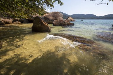 Yeşil su, yemyeşil orman, kayalar ve Ilha Grande, Costa Verde, Güney Rio de Janeiro, Brezilya için mavi gökyüzü güzel tropikal plaj manzara