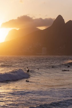 Güzel günbatımı manzara okyanus ve arka, Ipanema Plajı, Rio de Janeiro, Brezilya dağlardaki sörfçü ile