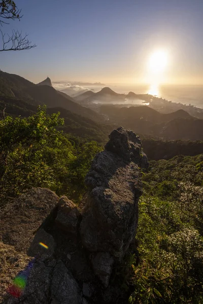 Beautiful landscape with rainforest, city and mountains by the sunrise seen from Pedra da Proa in Floresta da Tijuca (Tijuca Forest), Rio de Janeiro, Brazil