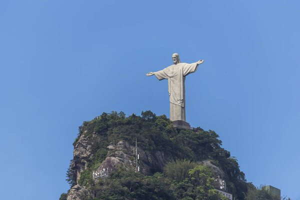 Статуя Христа Искупителя (Cristo Redentor) на вершине горы Корковадо (Morro do Corcovado) с голубым небом на спине, Рио-де-Жанейро, Бразилия
