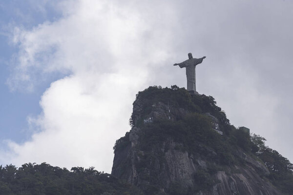 Статуя Христа Искупителя (Cristo Redentor) на вершине горы Корковадо (Morro do Corcovado) с голубым небом и красивыми облаками на спине, Рио-де-Жанейро, Бразилия
