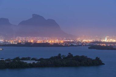 Beautiful landscape with view to urban lagoon and mountains on the back in Barra da Tijuca, Rio de Janeiro, Brazil clipart