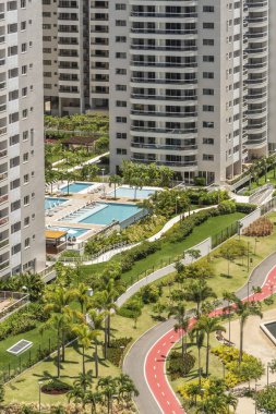 Beautiful landscape of green leisure area with swimming pool in residential buildings in Barra da Tijuca, Rio de Janeiro, Brazil clipart