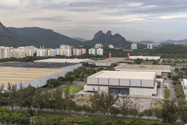 Landscape of view to large warehouses and convention center buildings with urban mountain on the back, Barra da Tijuca, Rio de Janeiro, Brazil