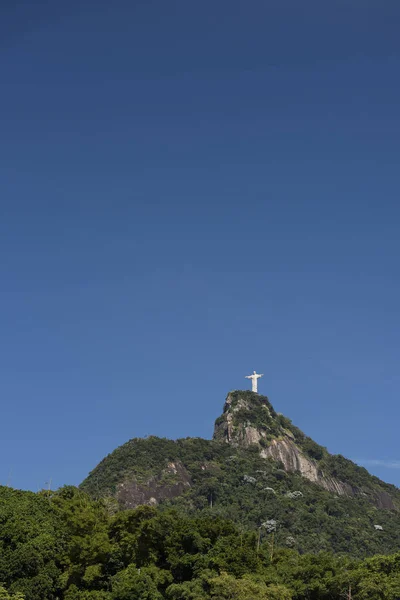 Christus de Verlosser standbeeld op de top van de groene beboste Corcovado mo — Stockfoto