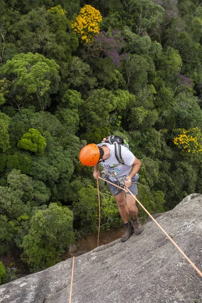 Giovane uomo adulto rotolamento su roccia verticale su bel verde — Foto Stock