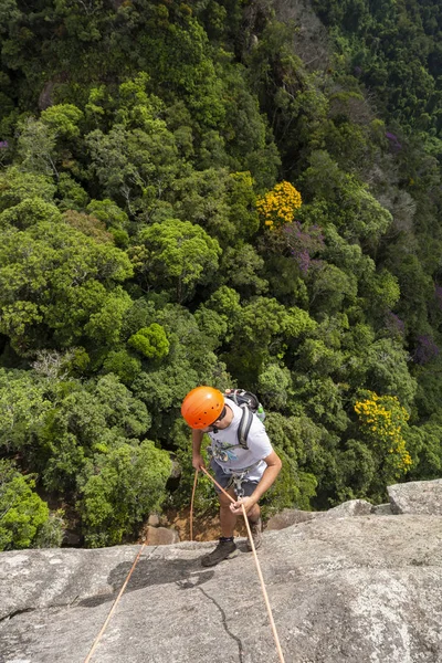 Giovane uomo adulto rotolamento su roccia verticale su bel verde — Foto Stock