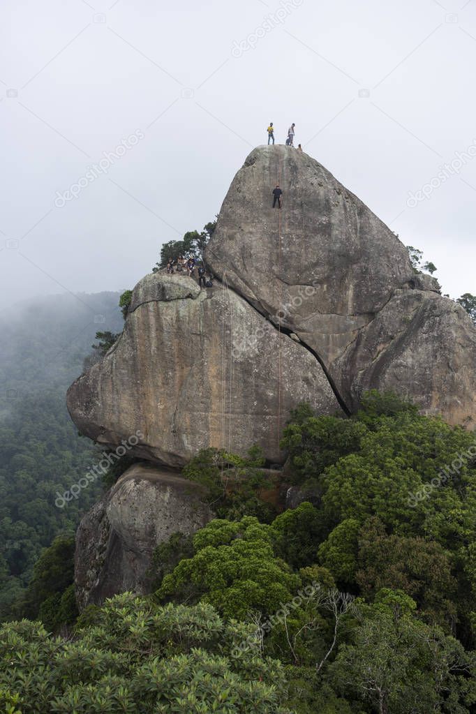 View to beautiful rocky peak landscape with people rappelling on