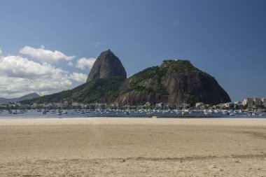 Güneşli bir günde, Rio de Janeiro, Brezilya 'daki Covid-19 salgını sırasında boş bir sahilden Sugar Loaf Dağı' na güzel bir manzara
