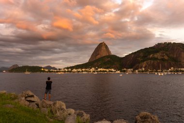 Rio de Janeiro, Brezilya 'da pembe ve turuncu bulutlu Sugar Loaf Dağı' na güzel bir gün batımı manzarası