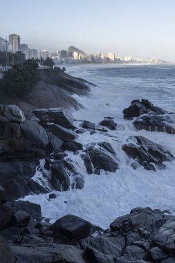 Mirante do Leblon 'dan okyanus manzarası seyreden insanlara güzel bir manzara ve kayalara çarpan dalgalar, Rio de Janeiro, Brezilya