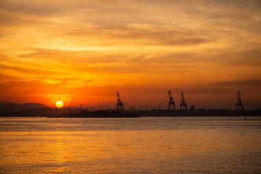 Endüstriyel merkezde, Rio de Janeiro, Brezilya 'da, okyanus kıyısında güneşin batışına güzel bir manzara