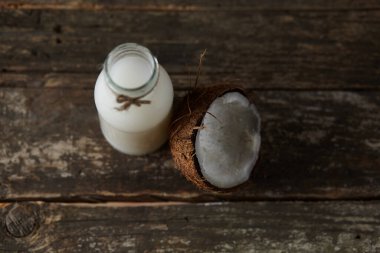 Ahşap bir arka planda yarım hindistan cevizi. Ahşap bir arka planda yarım hindistan cevizi. Hindistan cevizi kreması ve yağ..