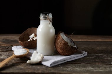 Ahşap bir arka planda yarım hindistan cevizi. Ahşap bir arka planda yarım hindistan cevizi. Hindistan cevizi kreması ve yağ..