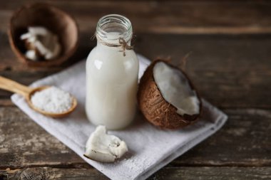 Ahşap bir arka planda yarım hindistan cevizi. Ahşap bir arka planda yarım hindistan cevizi. Hindistan cevizi kreması ve yağ..