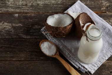 Ahşap bir arka planda yarım hindistan cevizi. Ahşap bir arka planda yarım hindistan cevizi. Hindistan cevizi kreması ve yağ..