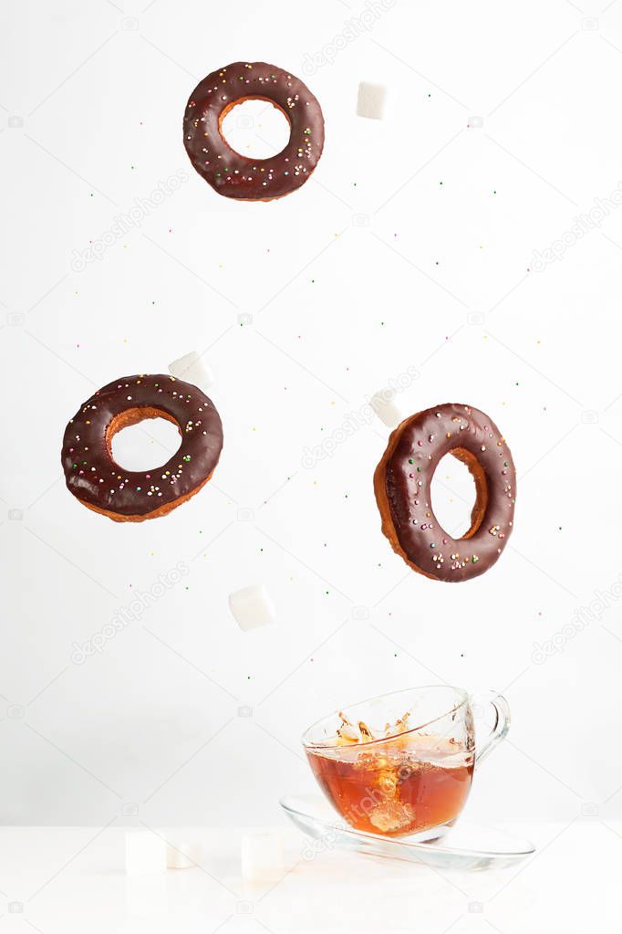 Levitating in the air donuts. Splashes of tea from the fallen