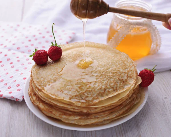 Delicious pancakes with honey and berries.