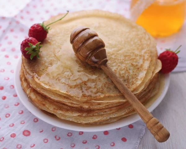Delicious pancakes with honey and berries.