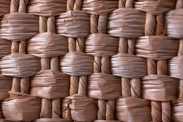 Weaving from dried vegetable fiber. Beautiful texture. Basket weaving. Beautiful, woven pattern of vegetable fiber.