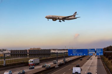 Frankfurt Airport, Almanya, 16 Şubat - 2018, Alman Otoban Otoban A5 Frankfurter Kreuz adlı iniş sırasında Frankfurt Havaalanı üzerinde akşam güneşi alacakaranlıkta uçan Etihad Airways uçağı Boeing 777
