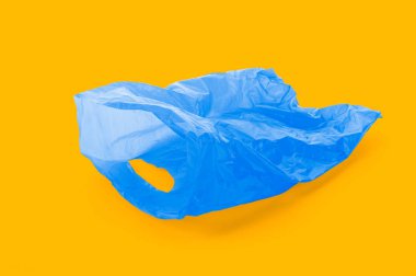 Boş mavi plastik çöp torbası tamamlayıcı turuncu zemin üzerinde yüzen,