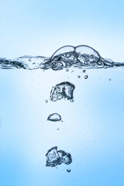 Unterwasserblasen in klarem Wasser auf blauem Hintergrund — Stockfoto
