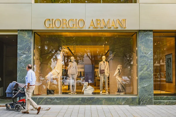Giorgio Armani lüks mağazası vitrininde giysiler sergileniyor.