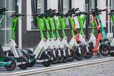 Bir grup markalı e-scooter bir paylaşım istasyonuna park etmiş.