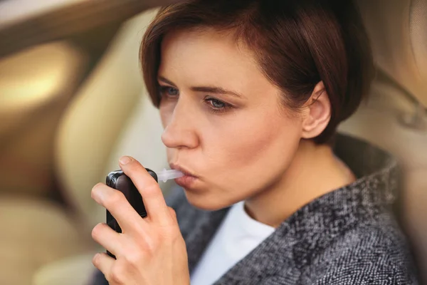 Frau mit Atemalkoholmessgerät im Auto — Stockfoto