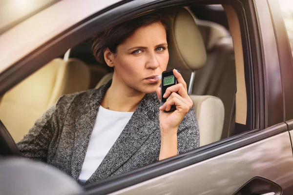 Kvinna med andedräkt alkohol analyzer i bilen — Stockfoto