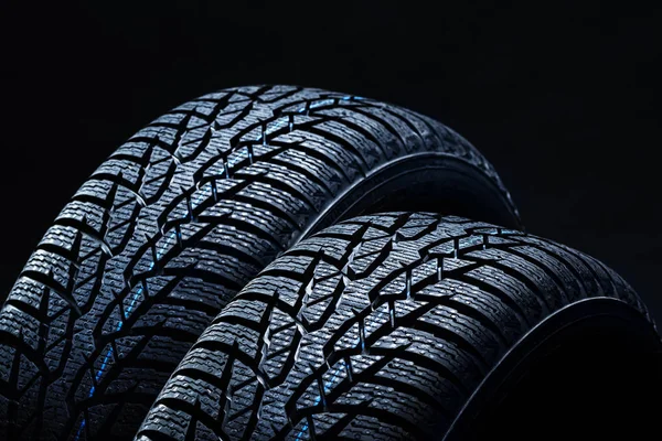 Neumáticos de invierno sobre fondo negro con iluminación contrastante — Foto de Stock