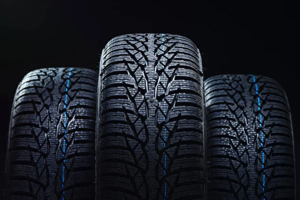 Zimní pneumatiky na černém pozadí s kontrastní osvětlení — Stock fotografie