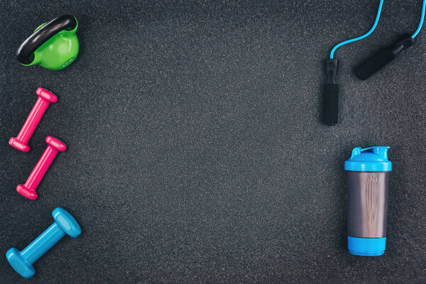 Fitness or bodybuilding background. Dumbbells on gym floor, top view