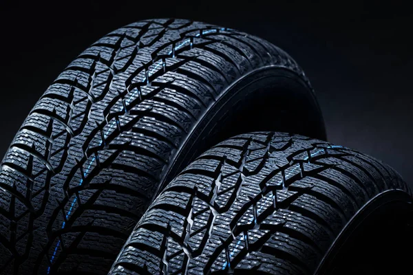 Neumáticos de invierno sobre fondo negro con iluminación contrastante — Foto de Stock
