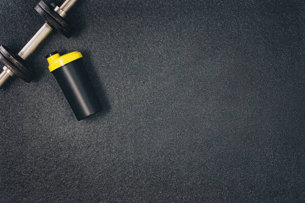 Fitness or bodybuilding background. Dumbbells on gym floor, top view